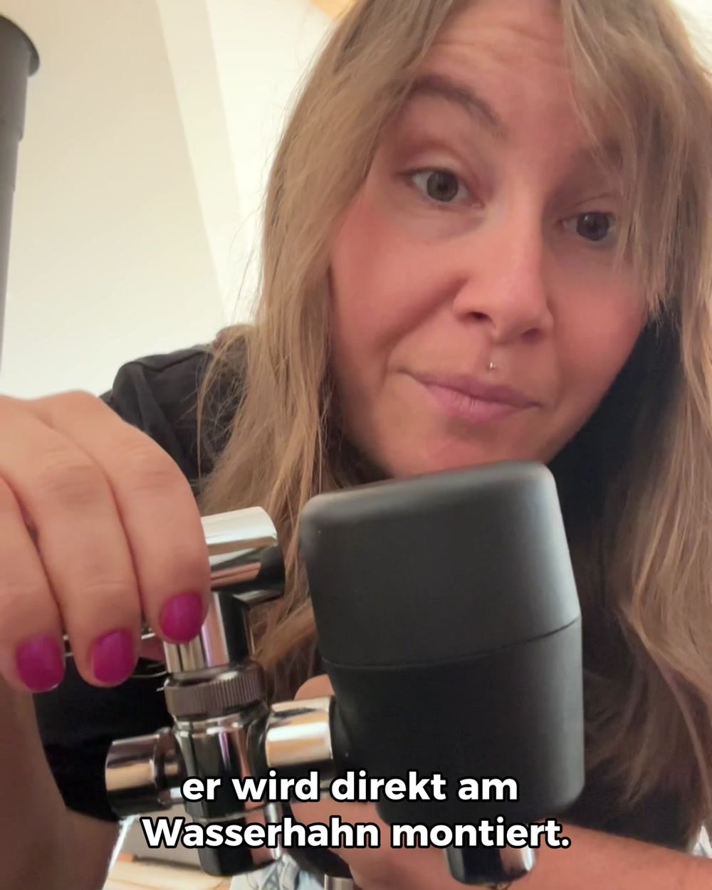 Creatorin zeigt in ihrer Küche, wie der riva Alva S am Wasserhahn montiert wird